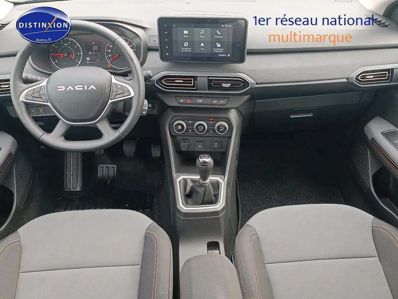 Intérieur noir de la Dacia Sandero 2025 vue de face, volant multifonction et écran tactile central visible.