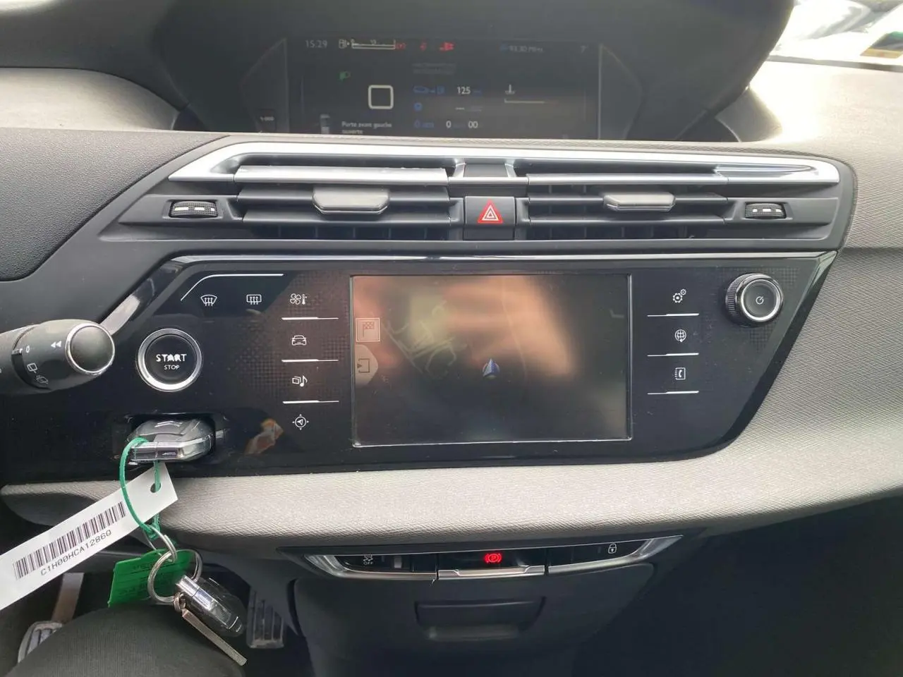 Tableau de bord noir et gris du Citroën Grand C4 Picasso 2015, avec écran tactile central et bouton start/stop visible.