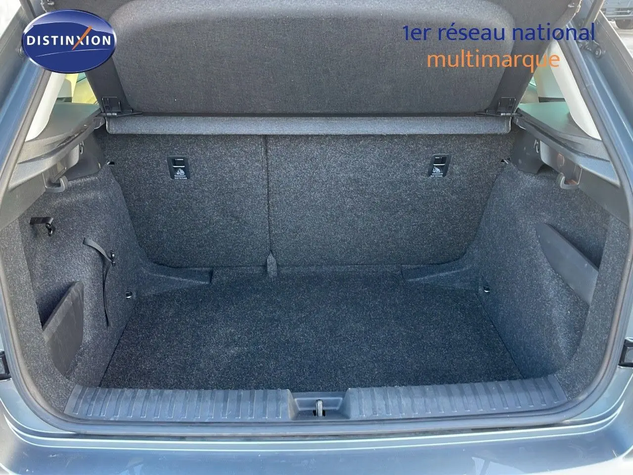 Coffre ouvert du Skoda Kamiq gris graphite métal 2024, vue intérieure montrant l'espace de chargement vide et les finitions en tissu gris.