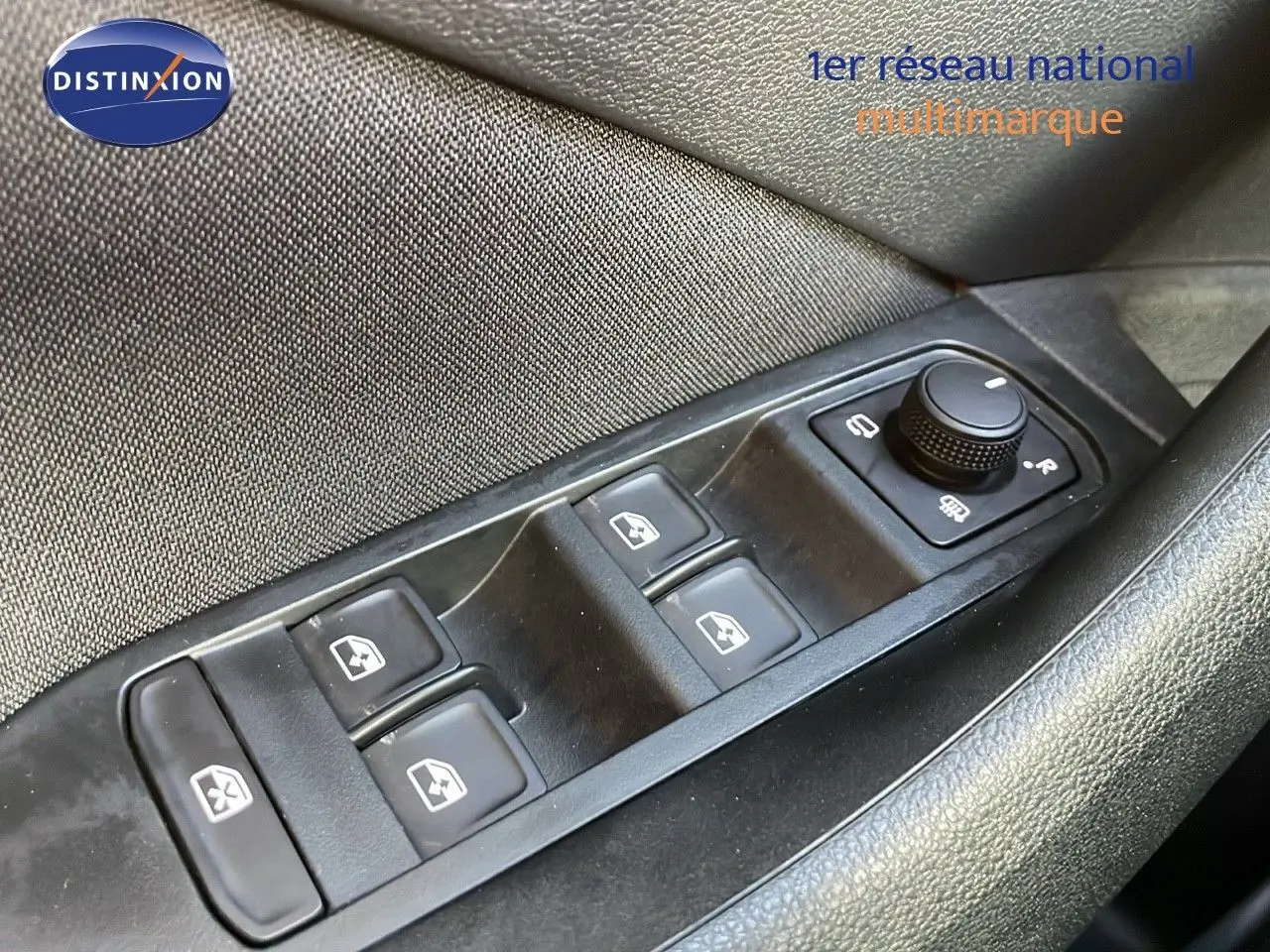Gros plan sur les commandes de lève-vitres et réglage des rétroviseurs côté conducteur du Skoda Kamiq gris graphite 2024.