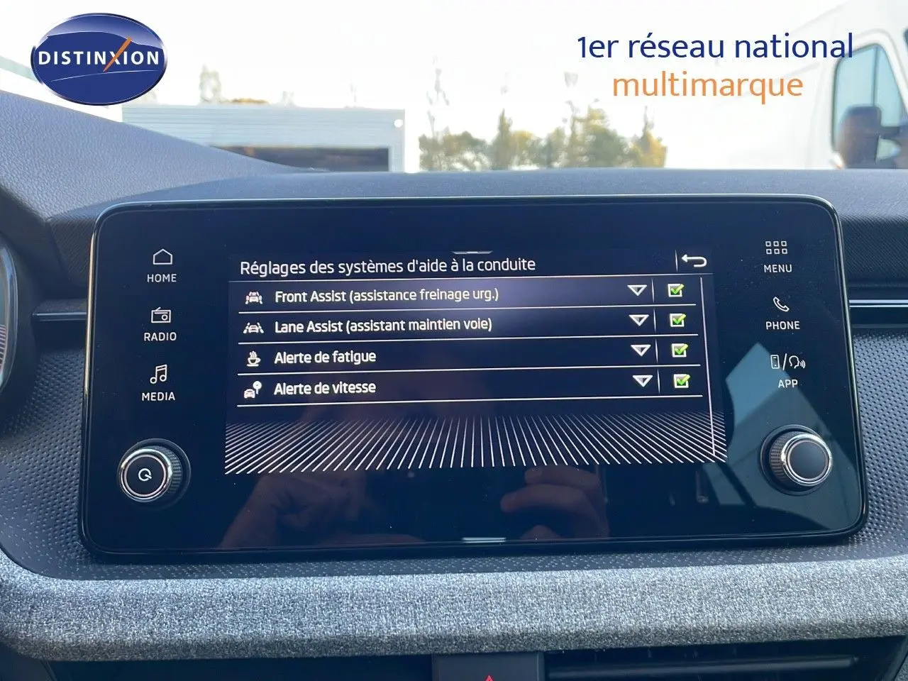 Écran tactile central du Skoda Kamiq gris graphite 2024 affichant les aides à la conduite activées.
