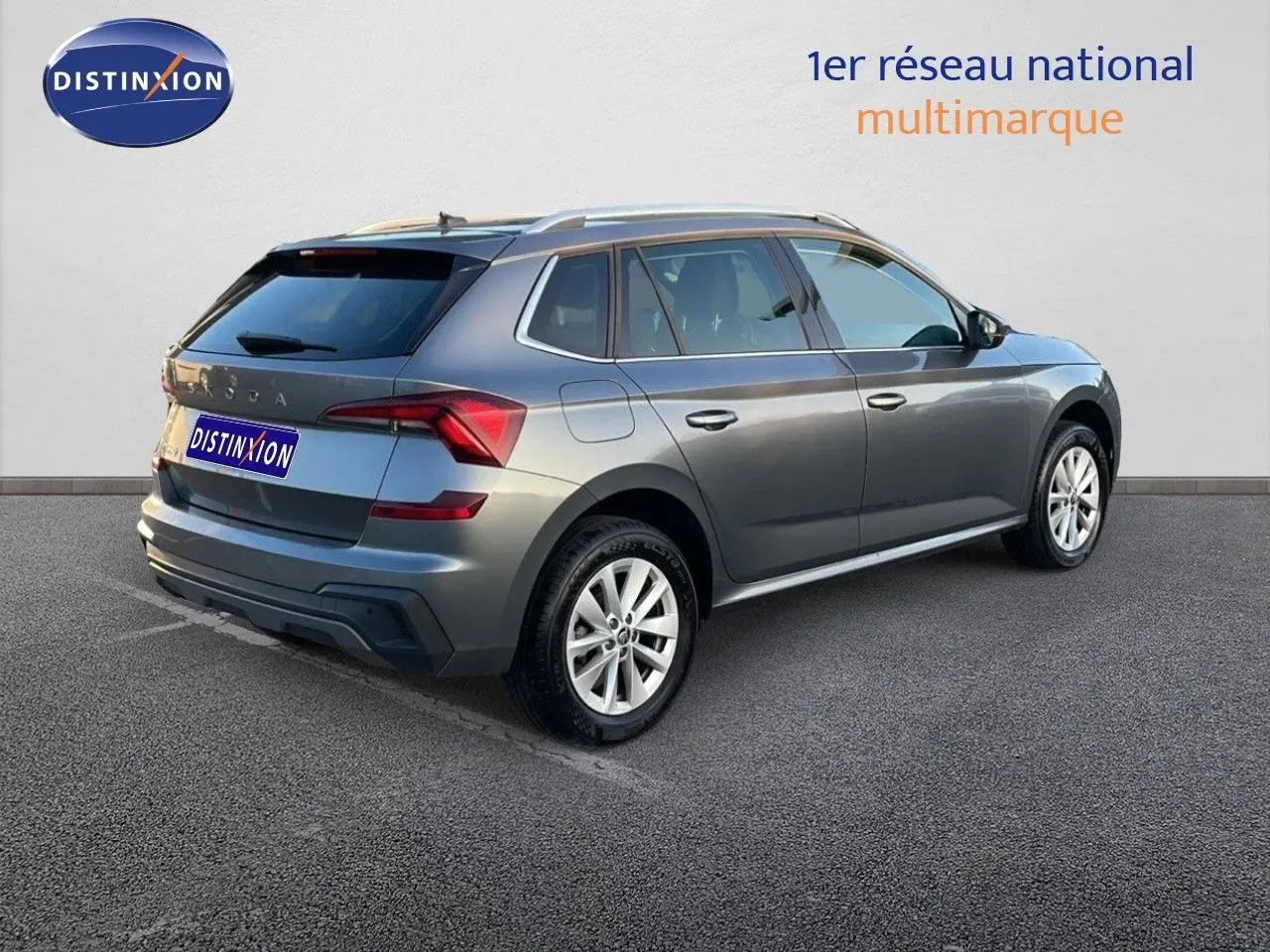 Vue 3/4 arrière droite d'un Skoda Kamiq gris graphite métal 2024 avec jantes alliage et toit surélevé.
