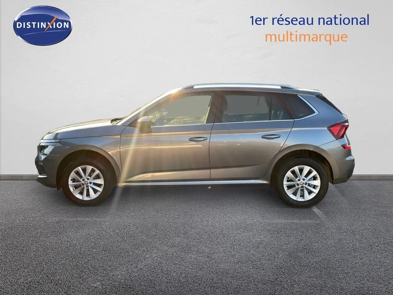 Profil côté gauche d'un Skoda Kamiq gris graphite métal 2024 avec jantes alliage et toit blanc.