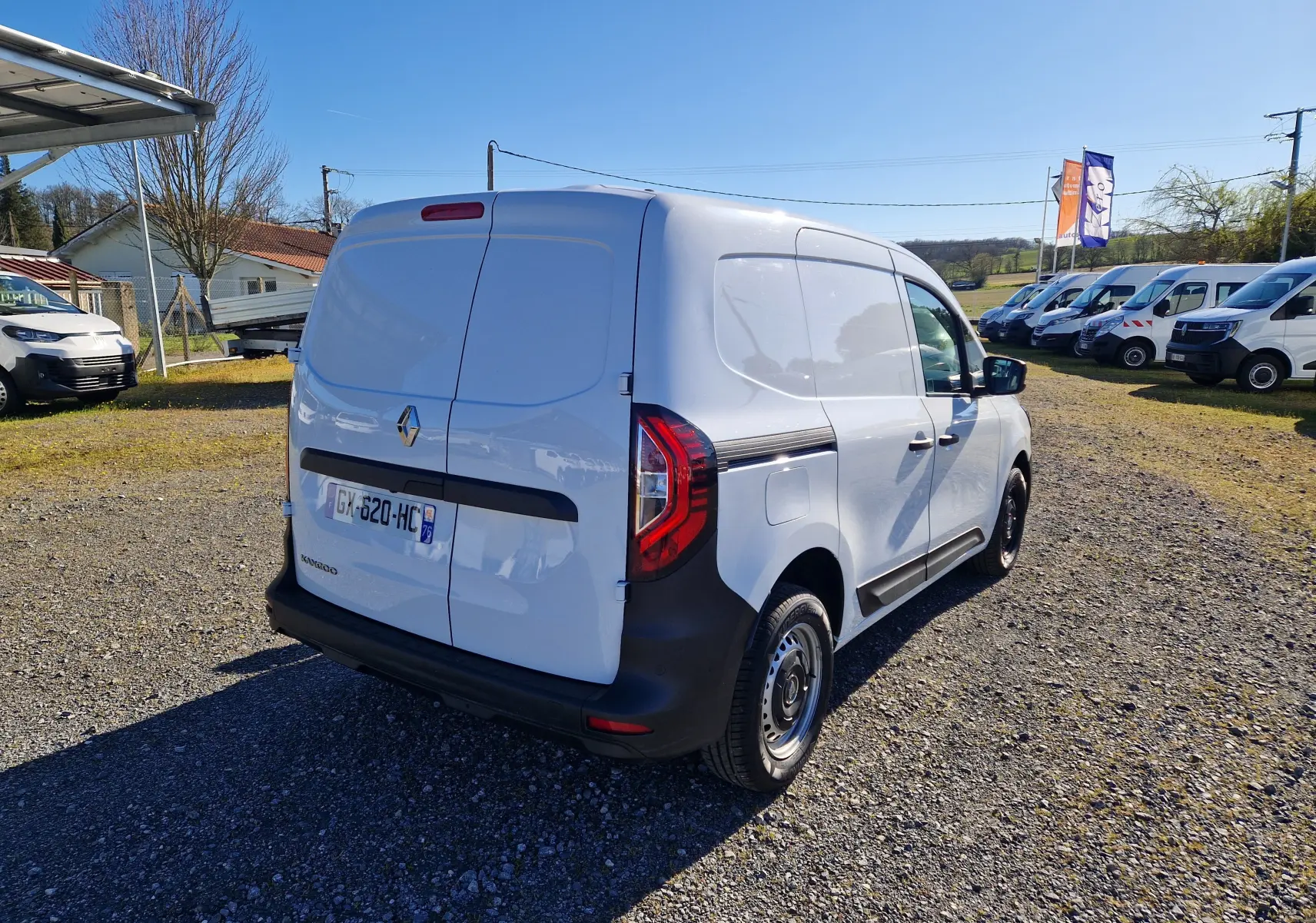 Vue 3/4 arrière droite d’un Renault Kangoo blanc utilitaire avec portes arrière battantes et feux LED distinctifs.