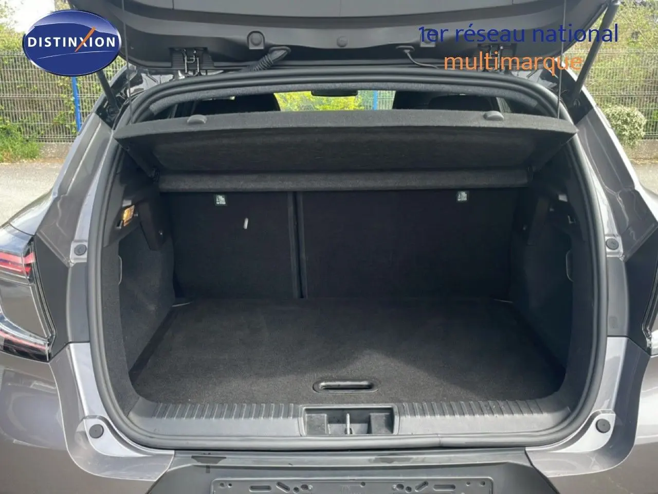 Coffre ouvert vu de l'arrière d'un Renault Captur gris cassiopée métal avec toit noir, version 2025.
