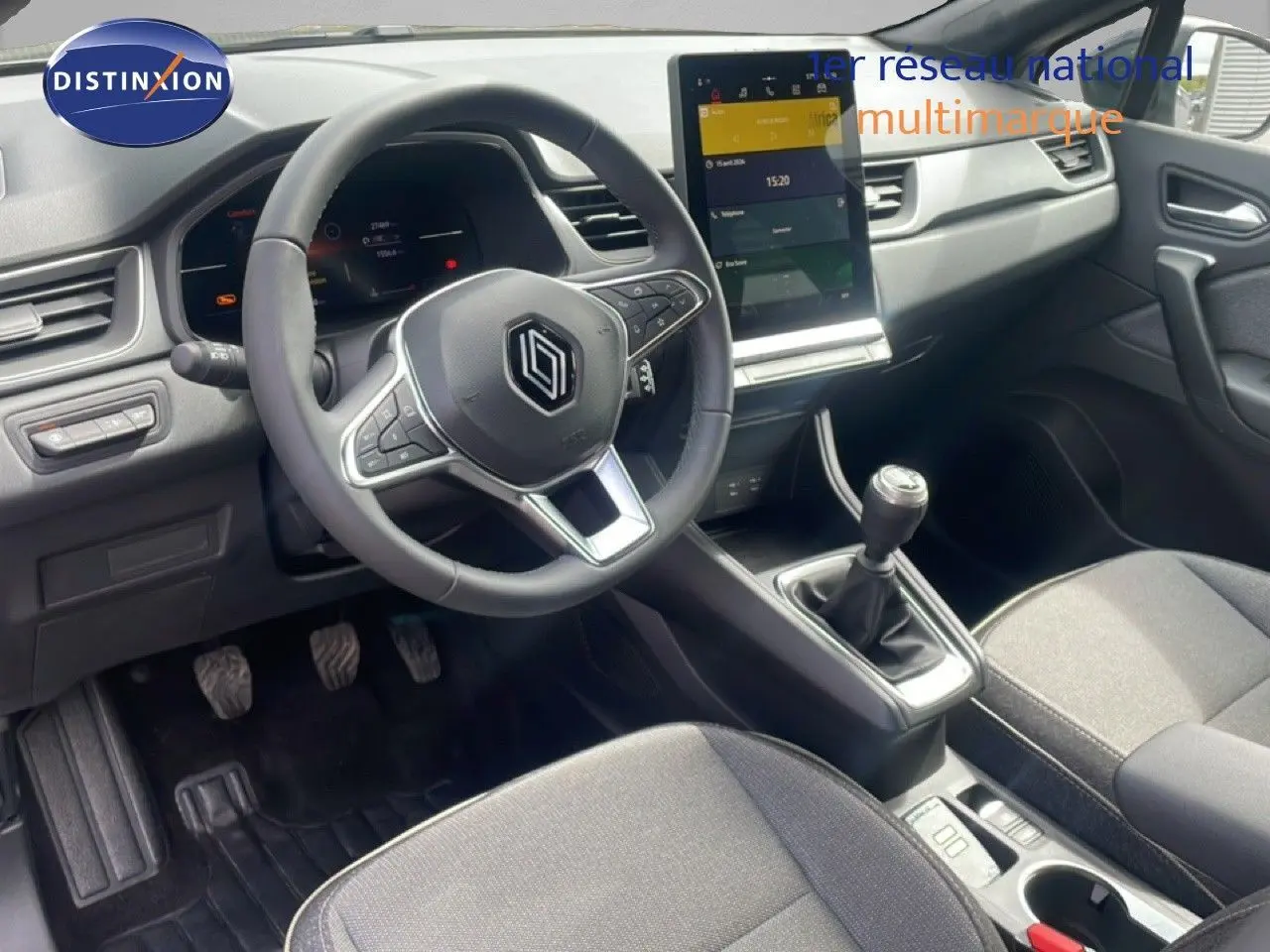 Vue intérieure côté conducteur du Renault Captur 2025, volant cuir, tableau de bord numérique et écran tactile vertical.