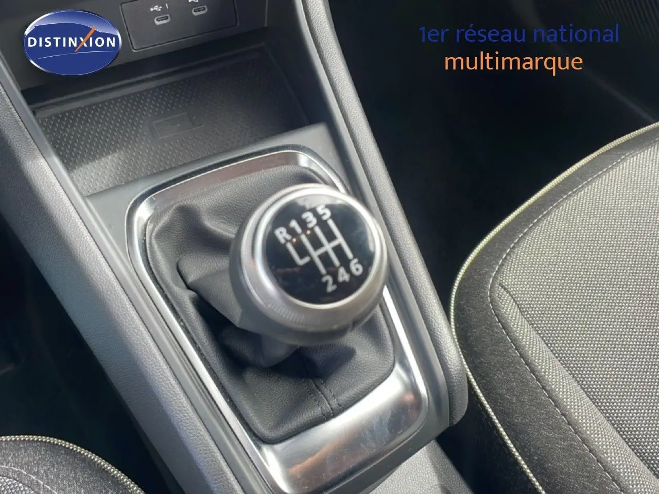 Gros plan sur le levier de vitesse manuel du Renault Captur 2025, intérieur tissu gris et console noire.