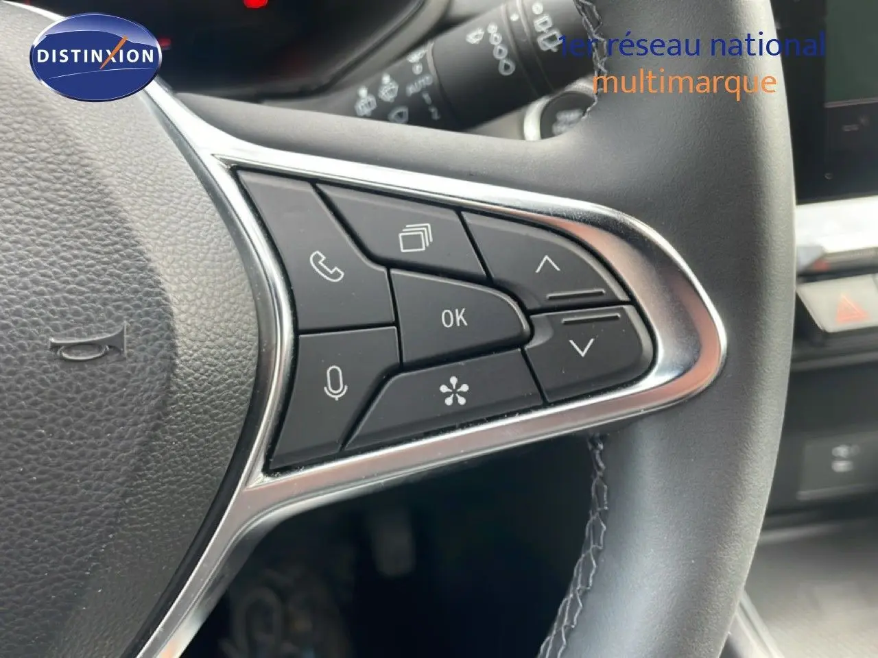 Gros plan sur les commandes multifonctions à droite du volant en cuir noir du Renault Captur 2025.
