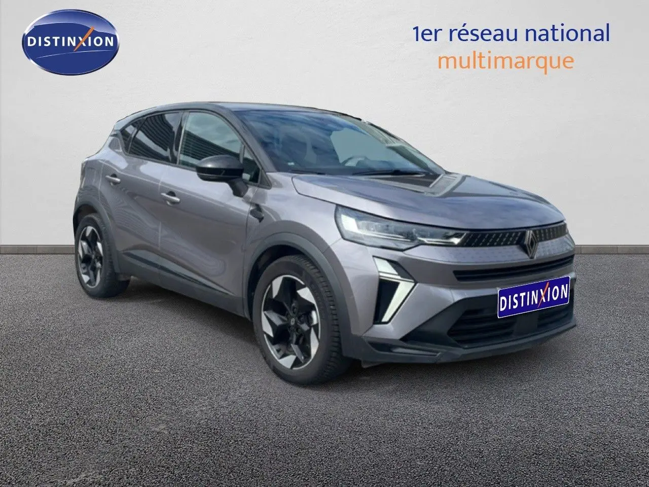 Renault Captur 2025 gris cassiopée métal avec toit noir, vue 3/4 avant droit, jantes alliage bicolores et calandre moderne.