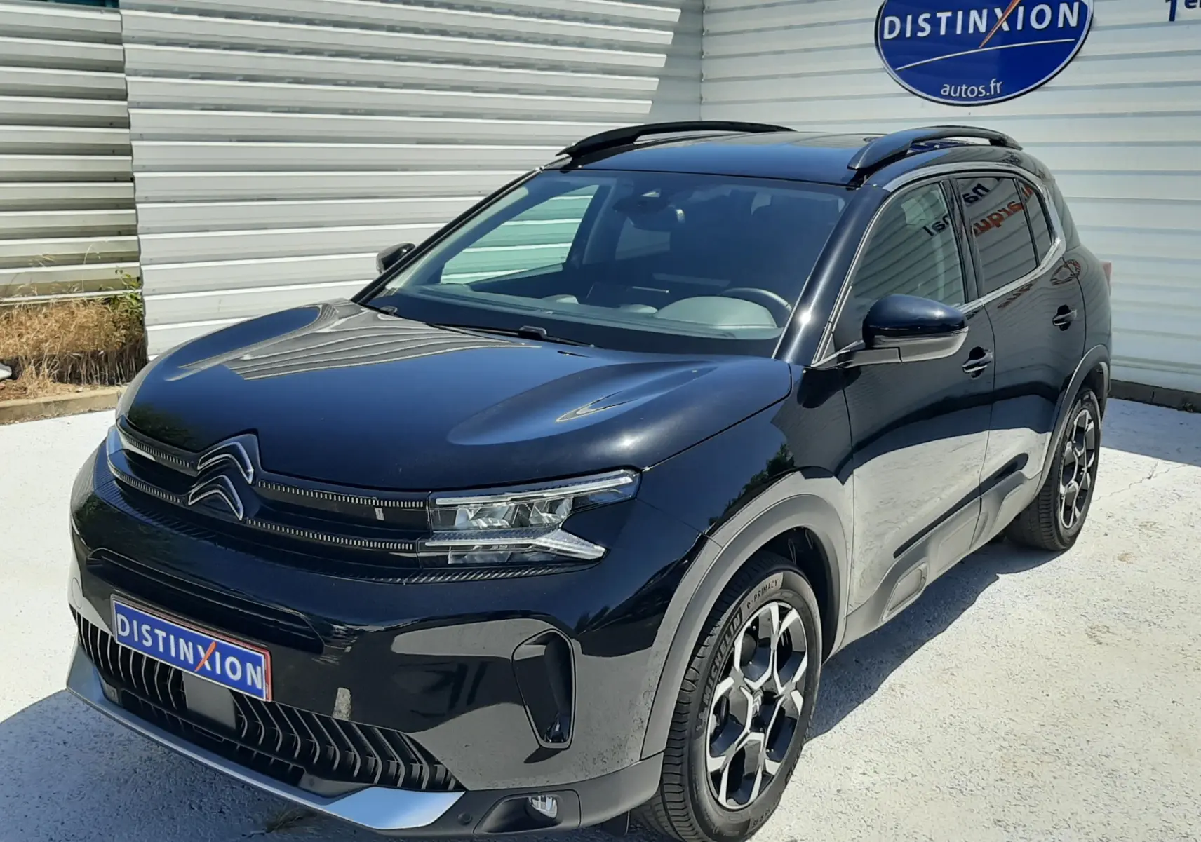 Vue 3/4 avant droite d'un Citroën C5 Aircross noir Perla Nera 2025 avec toit panoramique et jantes bi-ton.