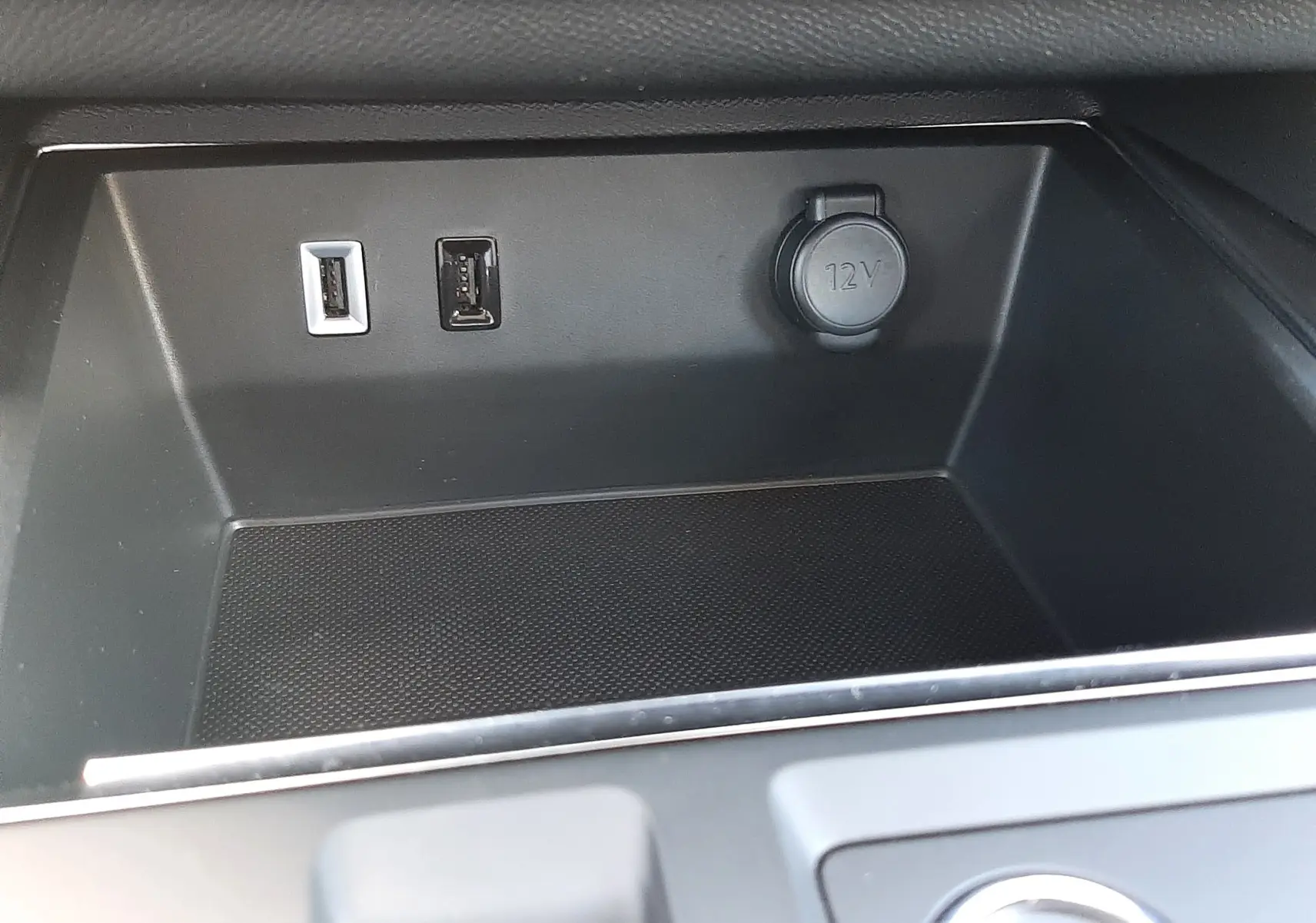 Vue rapprochée de la console centrale noire du Citroën C5 Aircross avec prises USB et prise 12V visibles.