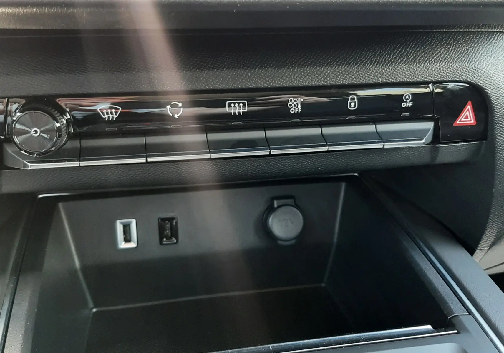 Vue rapprochée de la console centrale noire du Citroën C5 Aircross Ph.2 Hybrid avec commandes climatisation et prises USB et 12V.