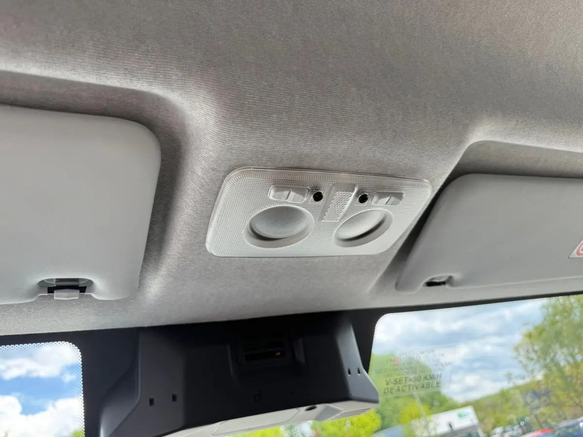 Vue intérieure du plafond gris clair de l'Iveco Daily 2.3 blanc, avec éclairages de lecture intégrés.