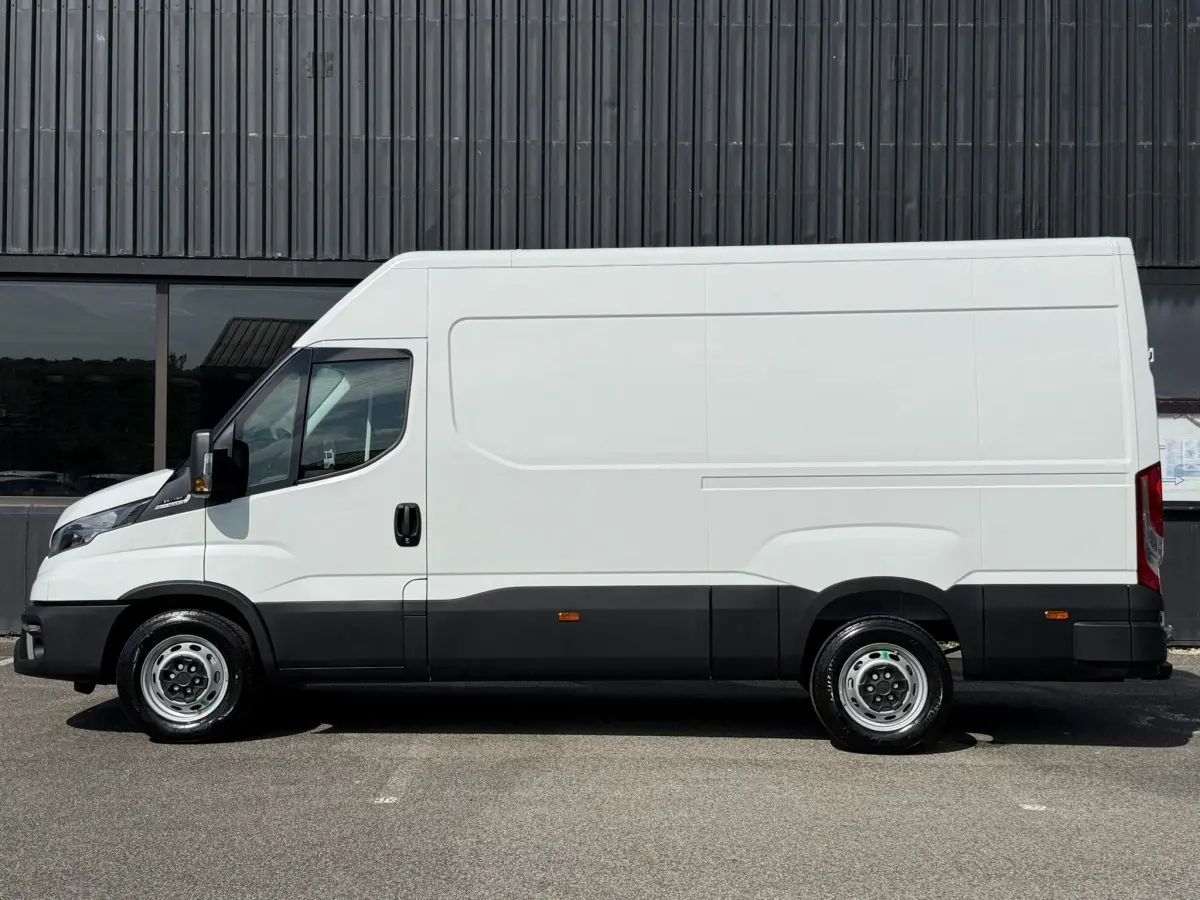 Vue latérale droite d’un utilitaire Iveco Daily blanc 2026 avec carrosserie haute et bas de caisse noir.