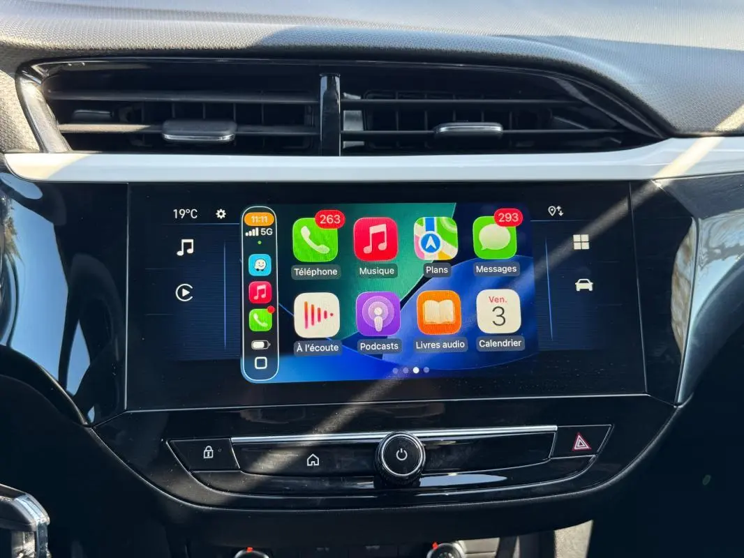 Vue rapprochée de l’écran tactile central de l’Opel Corsa rouge 2025, affichant l’interface Apple CarPlay.