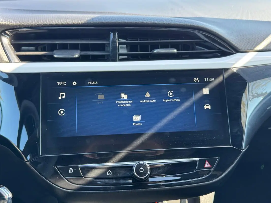 Écran tactile central de l’Opel Corsa rouge 2025, vue frontale du tableau de bord avec interface multimédia affichée.
