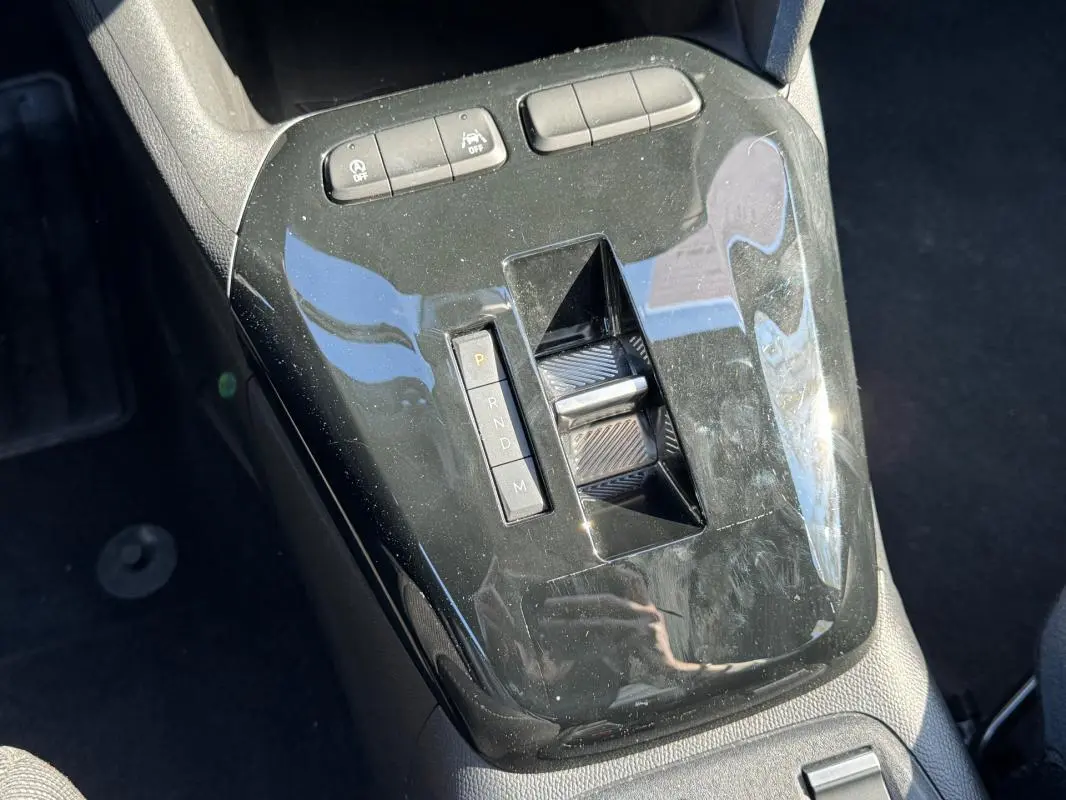 Vue rapprochée de la console centrale noire brillante avec sélecteur de boîte automatique de l’Opel Corsa rouge 2025.