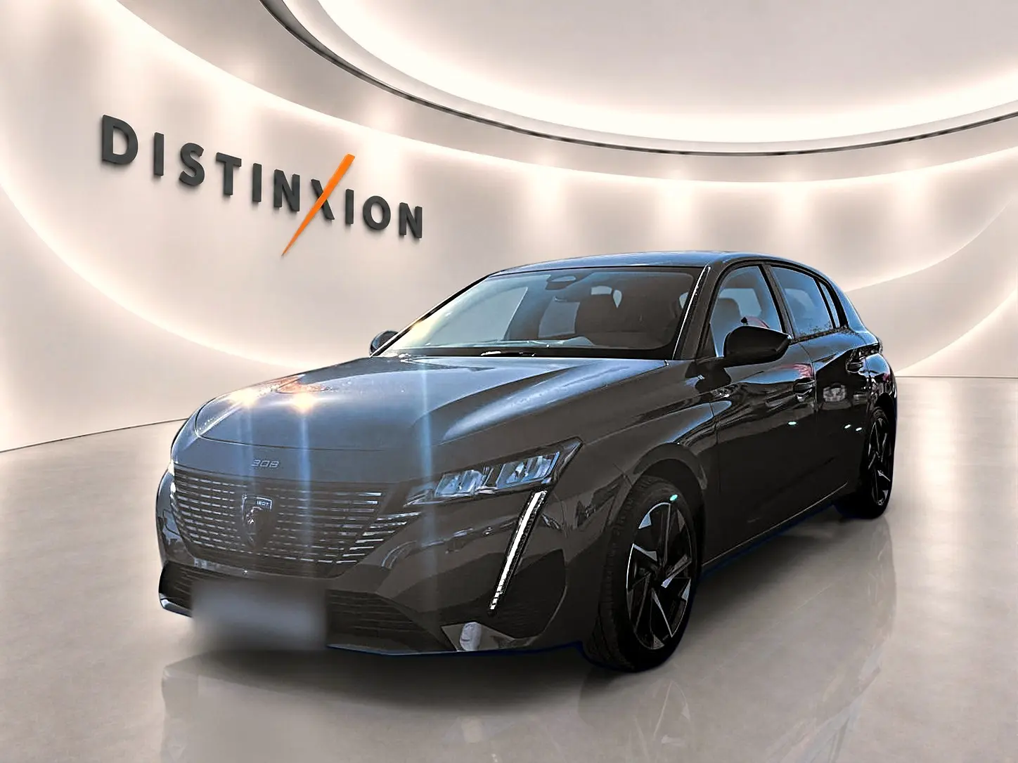 Vue 3/4 avant droite d'une Peugeot 308 gris selenium avec phares LED et jantes alliage noires dans un showroom lumineux.