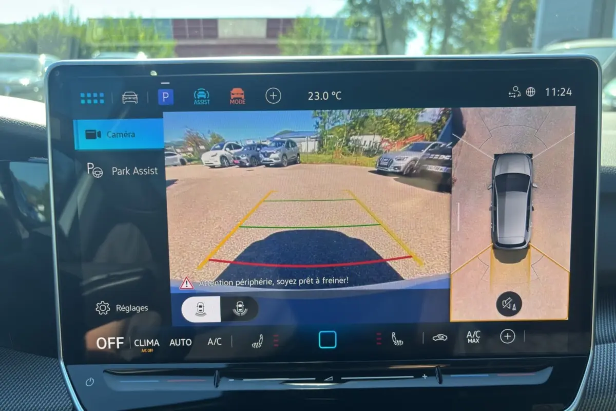 Écran tactile intérieur affichant la caméra 360° et l’aide au stationnement d’une Volkswagen Golf blanche.