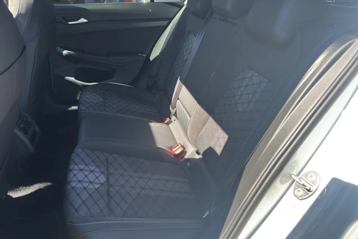 Vue intérieure côté droit sur la banquette arrière en tissu noir à motifs géométriques de la Volkswagen Golf blanc oryx.