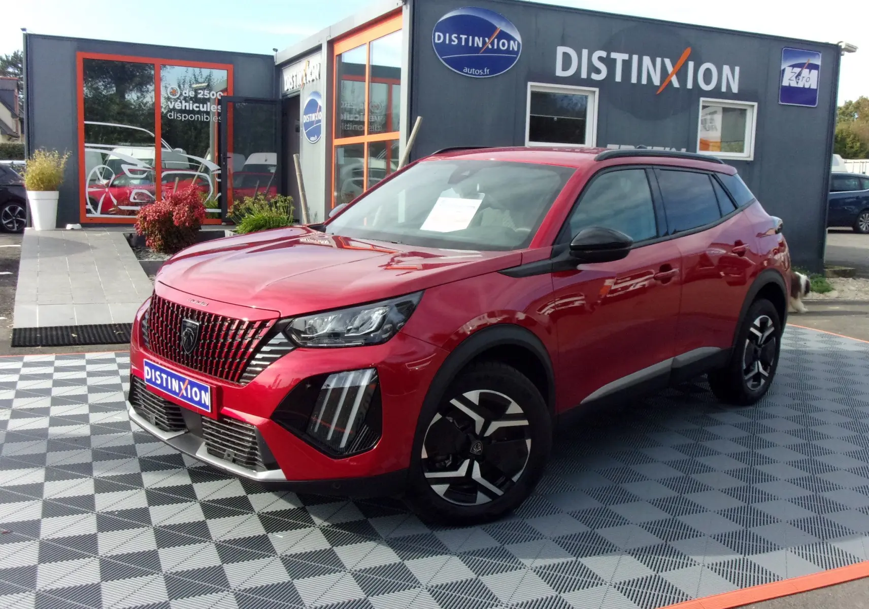 Peugeot 2008 rouge Elixir vue 3/4 avant droit, avec calandre distinctive et jantes noires au design moderne.