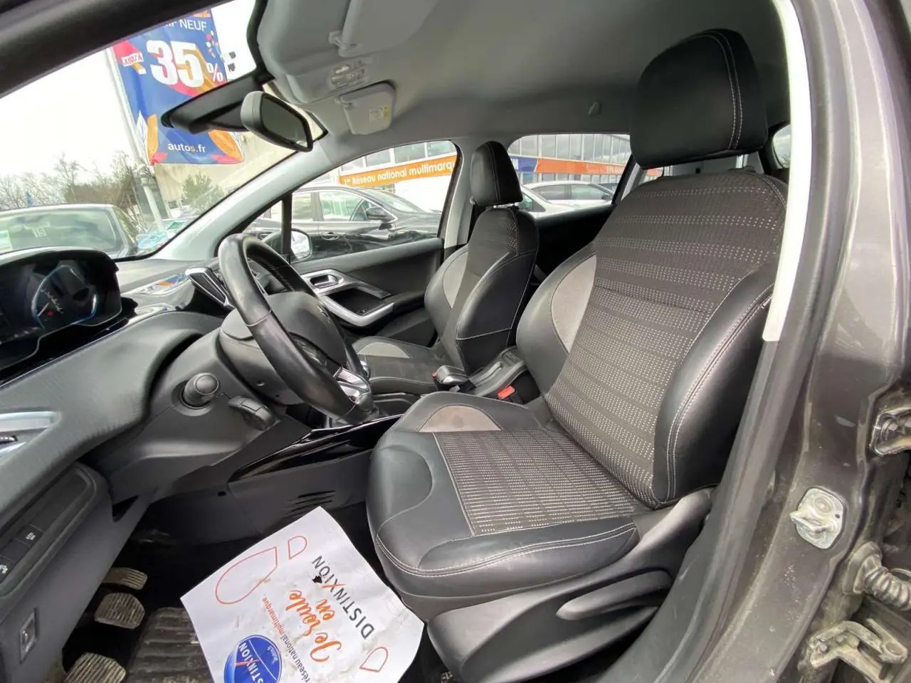 Intérieur avant droit du Peugeot 2008 gris platinium 2019, montrant les sièges en tissu et cuir et le tableau de bord moderne.