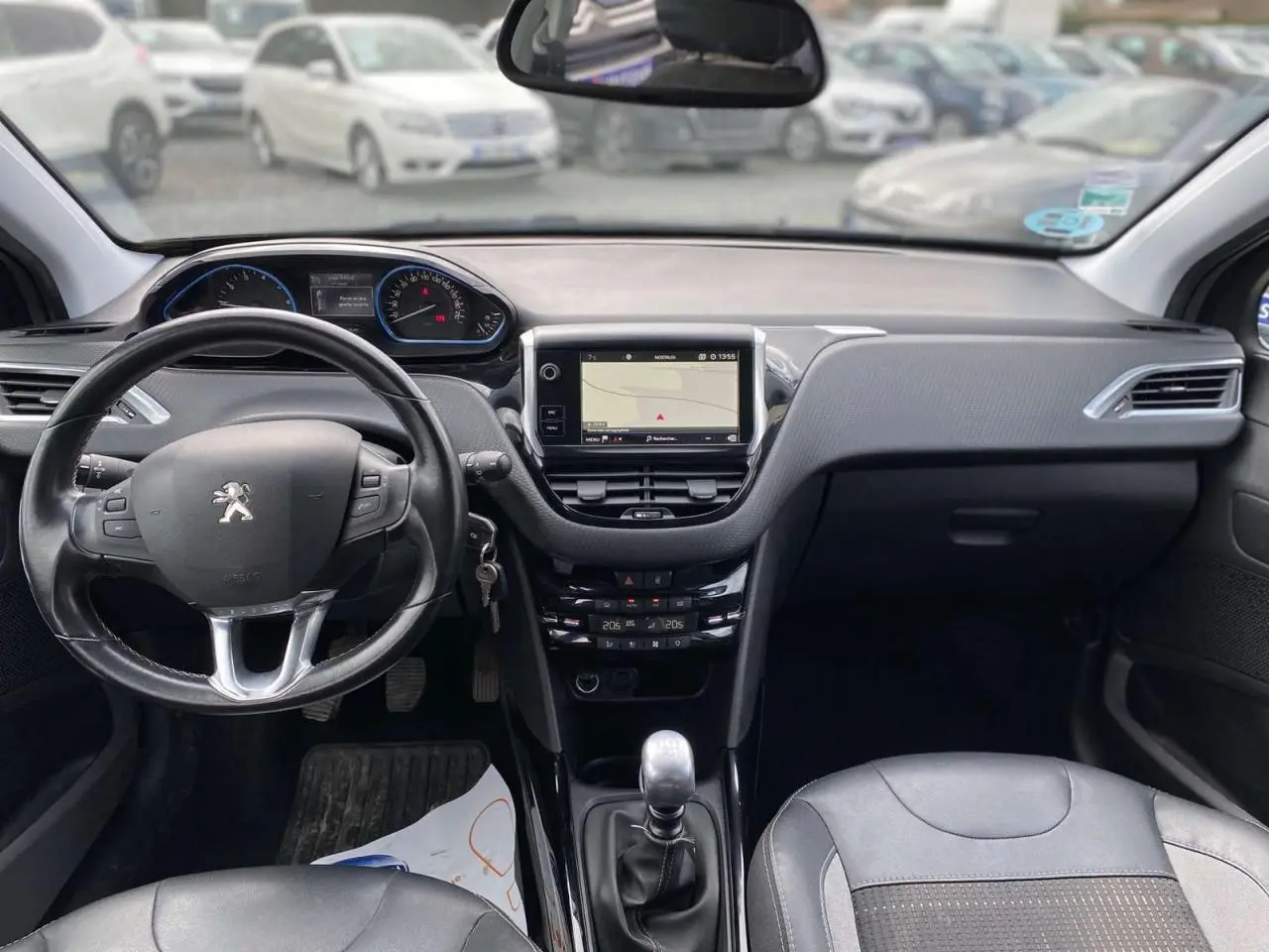 Intérieur de la Peugeot 2008 2019, vue de face sur le tableau de bord et volant noir avec écran tactile central.
