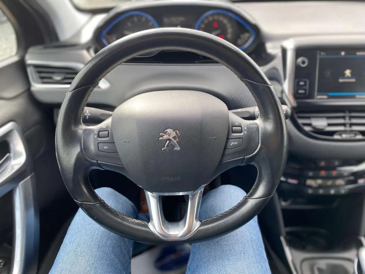 Vue centrée sur le volant cuir Peugeot 2008 2019, avec tableau de bord et écran tactile en arrière-plan.