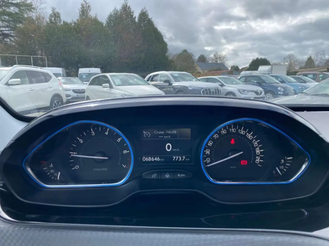 Vue du tableau de bord de la Peugeot 2008 gris platinium, affichant le compteur et l'ordinateur de bord à l'arrêt.