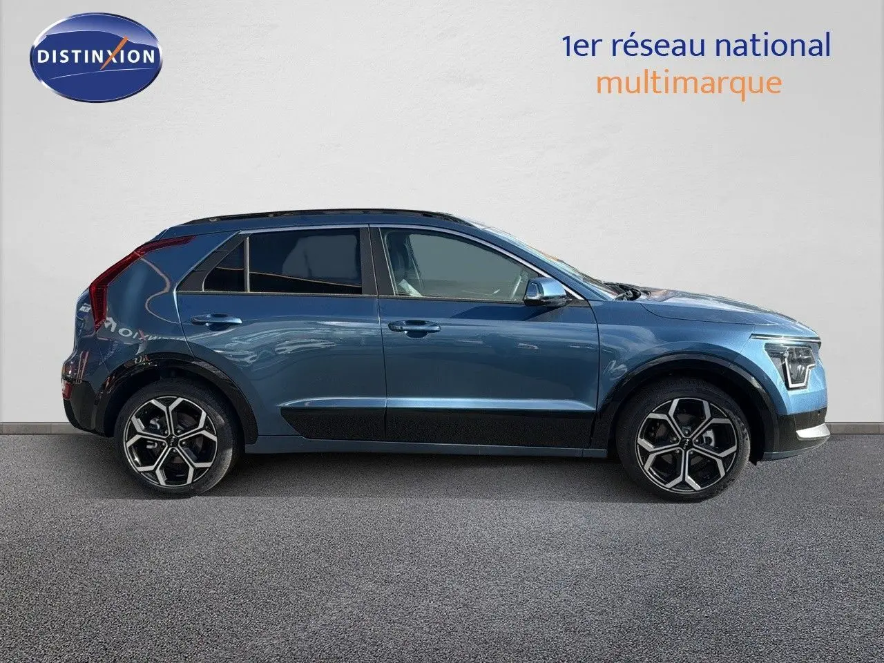 KIA Niro hybride rechargeable bleu minéral métal vu de profil côté gauche, avec jantes bi-ton et lignes modernes.