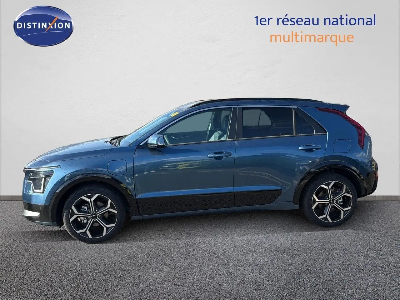 Vue latérale droite d'un KIA NIRO hybride rechargeable bleu minéral métal avec jantes alliage bi-ton et toit noir.