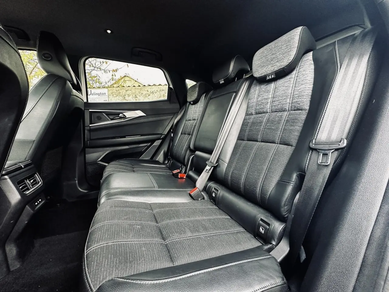 Vue latérale intérieure du siège arrière noir du Renault Austral 2024 avec ceintures et appuie-têtes visibles.