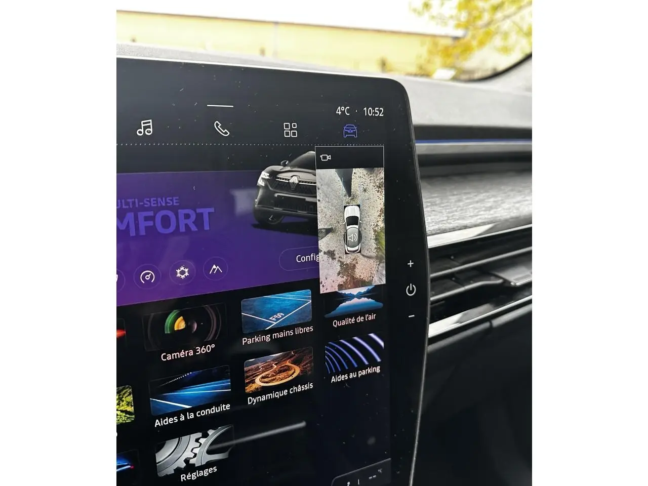 Écran tactile intérieur du Renault Austral blanc montrant la vue 360° et les aides au stationnement.