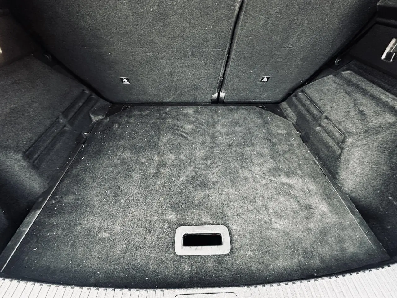 Vue intérieure du coffre du Renault Austral 2024 blanc, montrant la surface de chargement avec tapis noir.