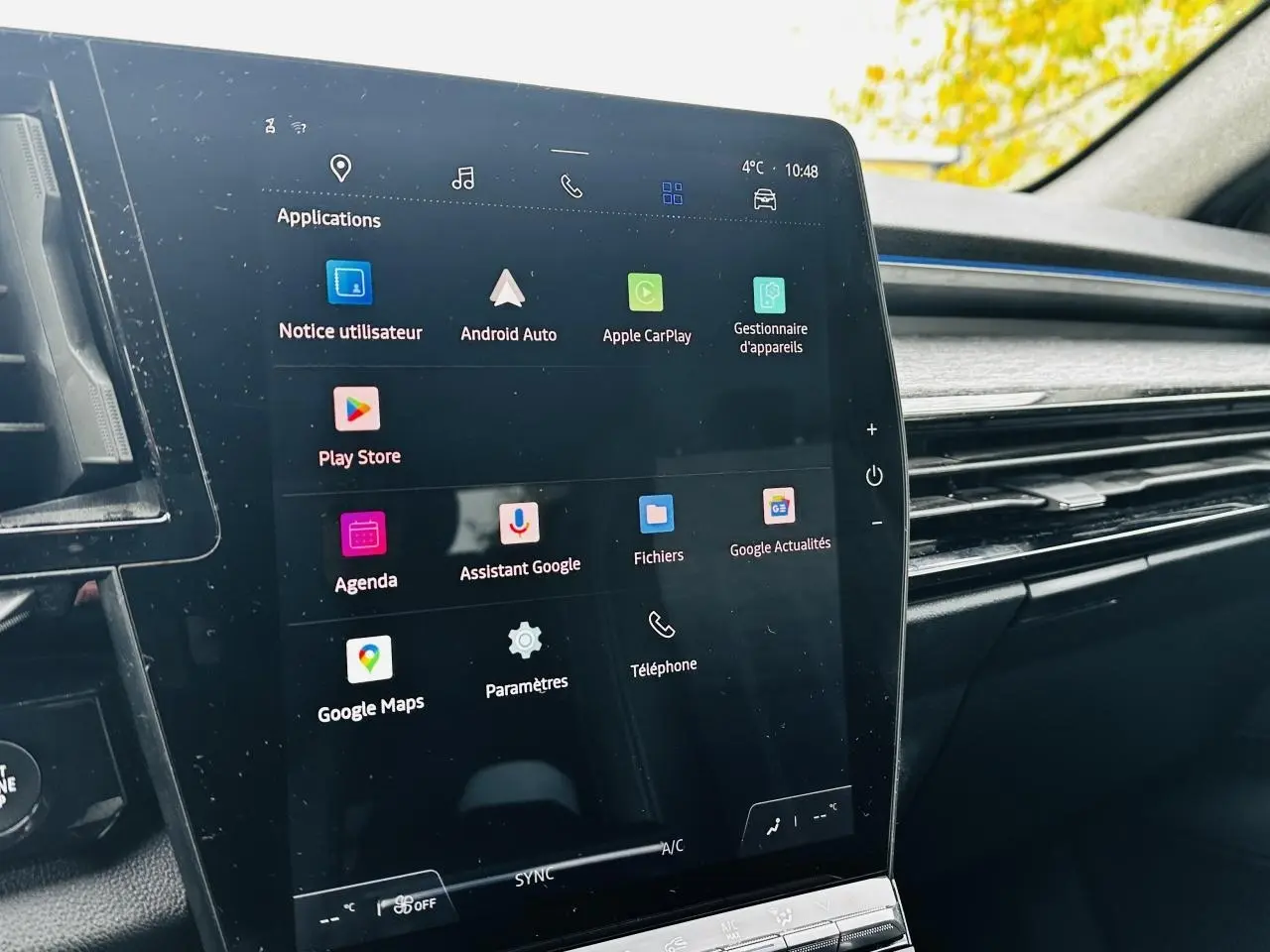 Écran tactile central vertical affichant les applications Google dans l'habitacle du Renault Austral blanc, vue de côté droit.
