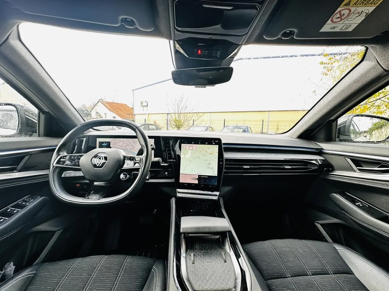 Vue intérieure avant du Renault Austral 2024 avec tableau de bord numérique et écran tactile central vertical.