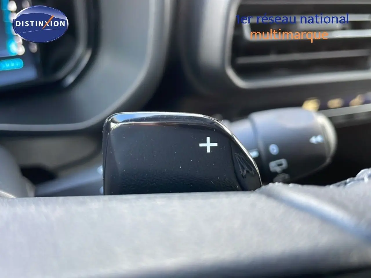 Gros plan sur la palette de passage de vitesses droite du Citroën Berlingo blanc glacier, intérieur noir visible en arrière-plan.
