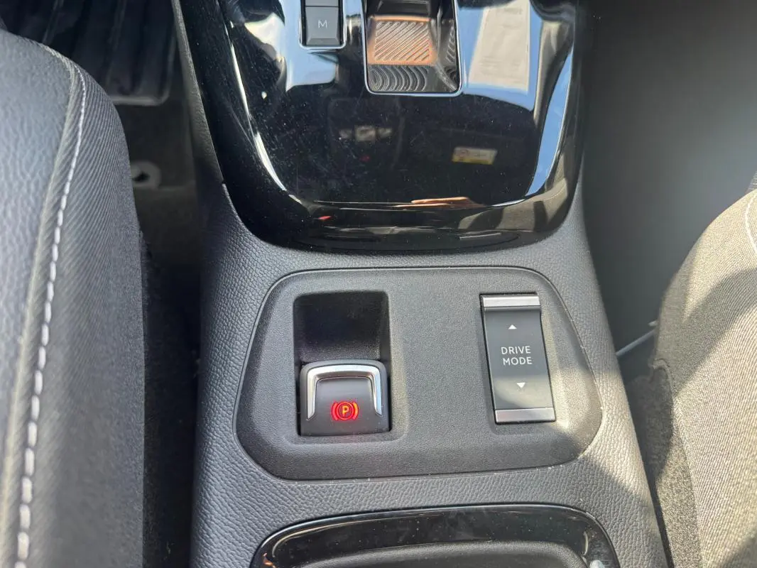 Vue rapprochée de la console centrale de l’Opel Corsa noire 2025, avec frein à main électronique et bouton Drive Mode.