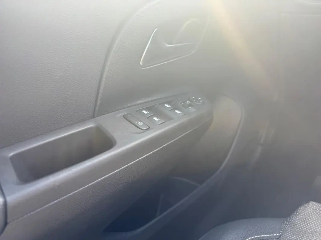 Détail de la porte côté conducteur de l’Opel Corsa 2025 noire, avec commandes des vitres et poignée intérieure visibles.