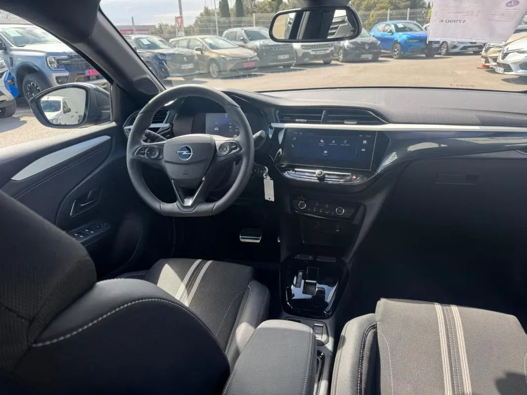 Vue intérieure avant de l’Opel Corsa 2025 noire, montrant le volant, tableau de bord digital et console centrale moderne.