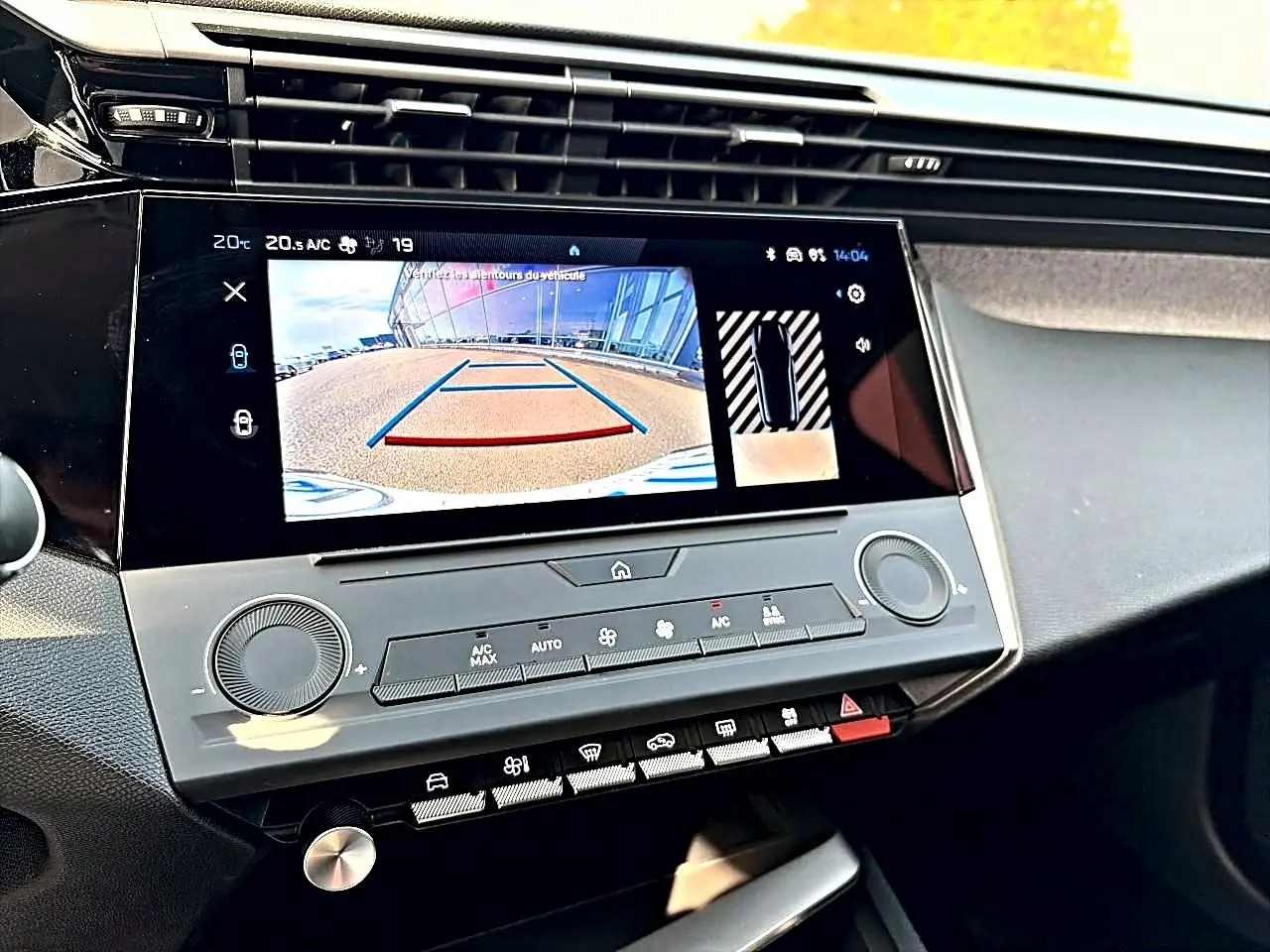 Écran tactile central affichant la caméra de recul dans l’habitacle d’une Peugeot 308 noire, vue de face.
