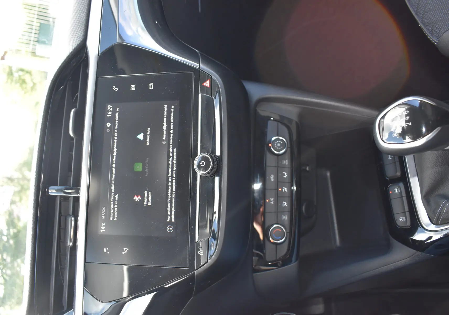 Vue rapprochée de la console centrale et levier de vitesse manuelle d'une Opel Corsa gris 2021 avec écran tactile et commandes climatisation.