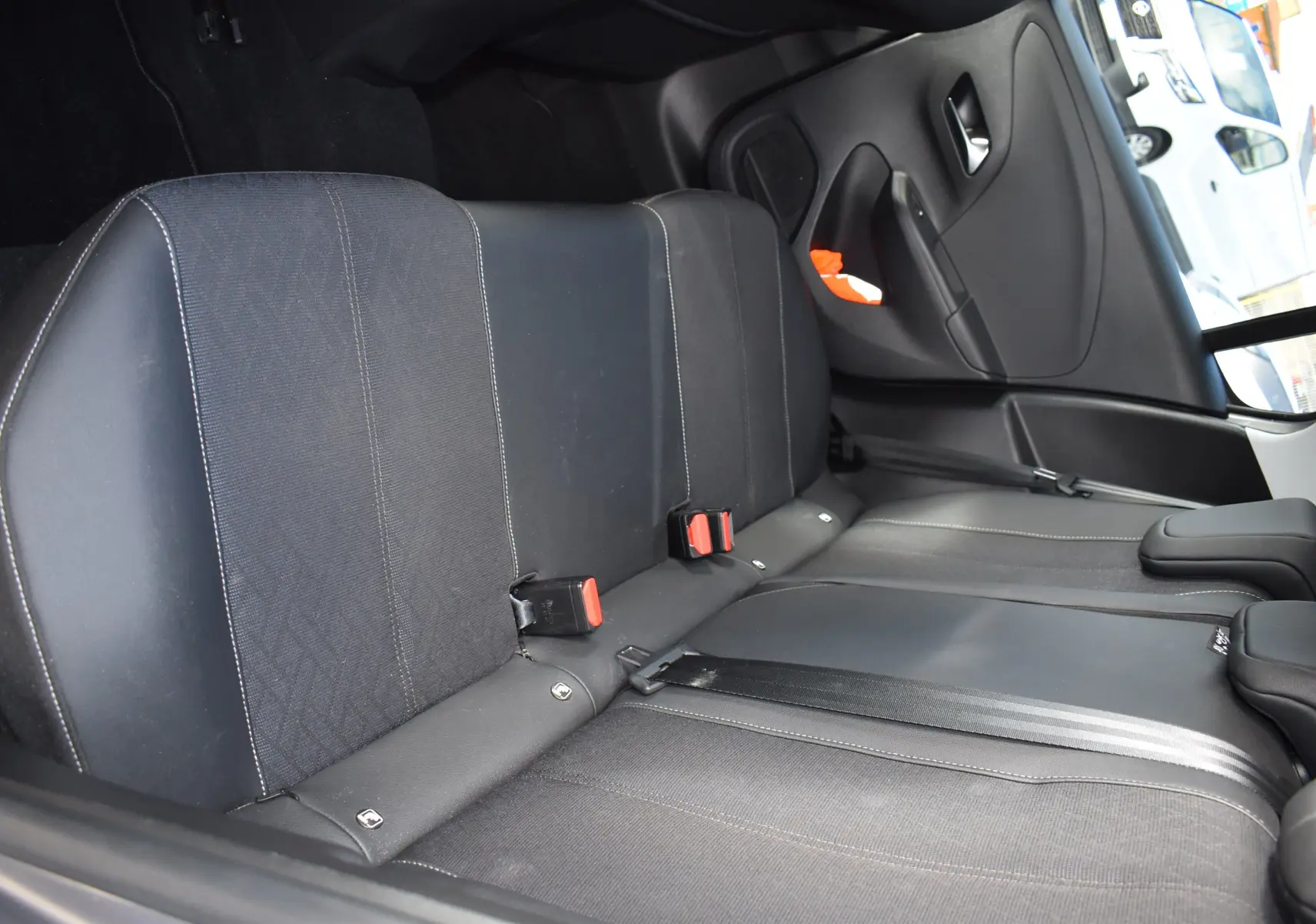 Vue intérieure sur les sièges arrière noirs de la Opel Corsa 1.2 Turbo 2021 avec ceintures et habillage tissu-cuir.