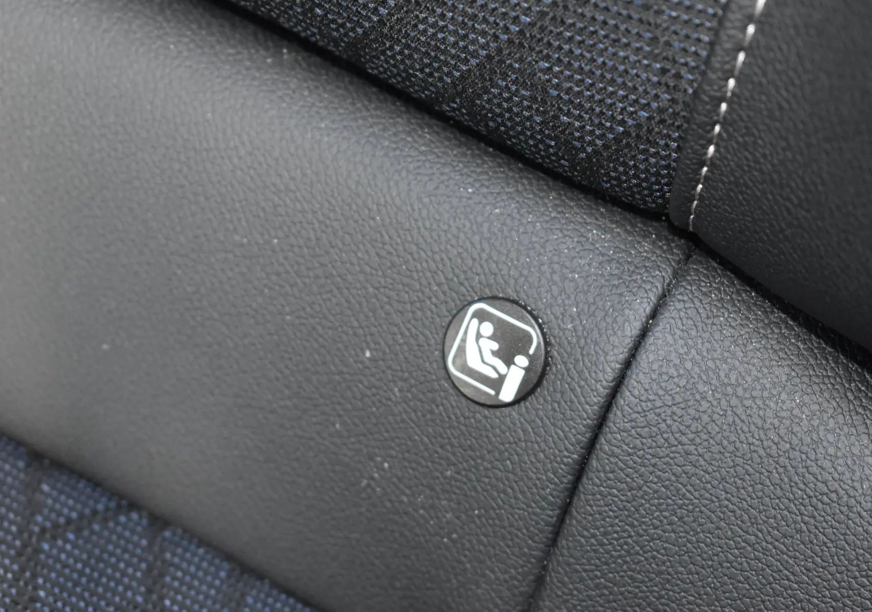 Gros plan sur l'icône ISOFIX sur la banquette arrière en tissu et cuir noir d'une Opel Corsa gris 2021.