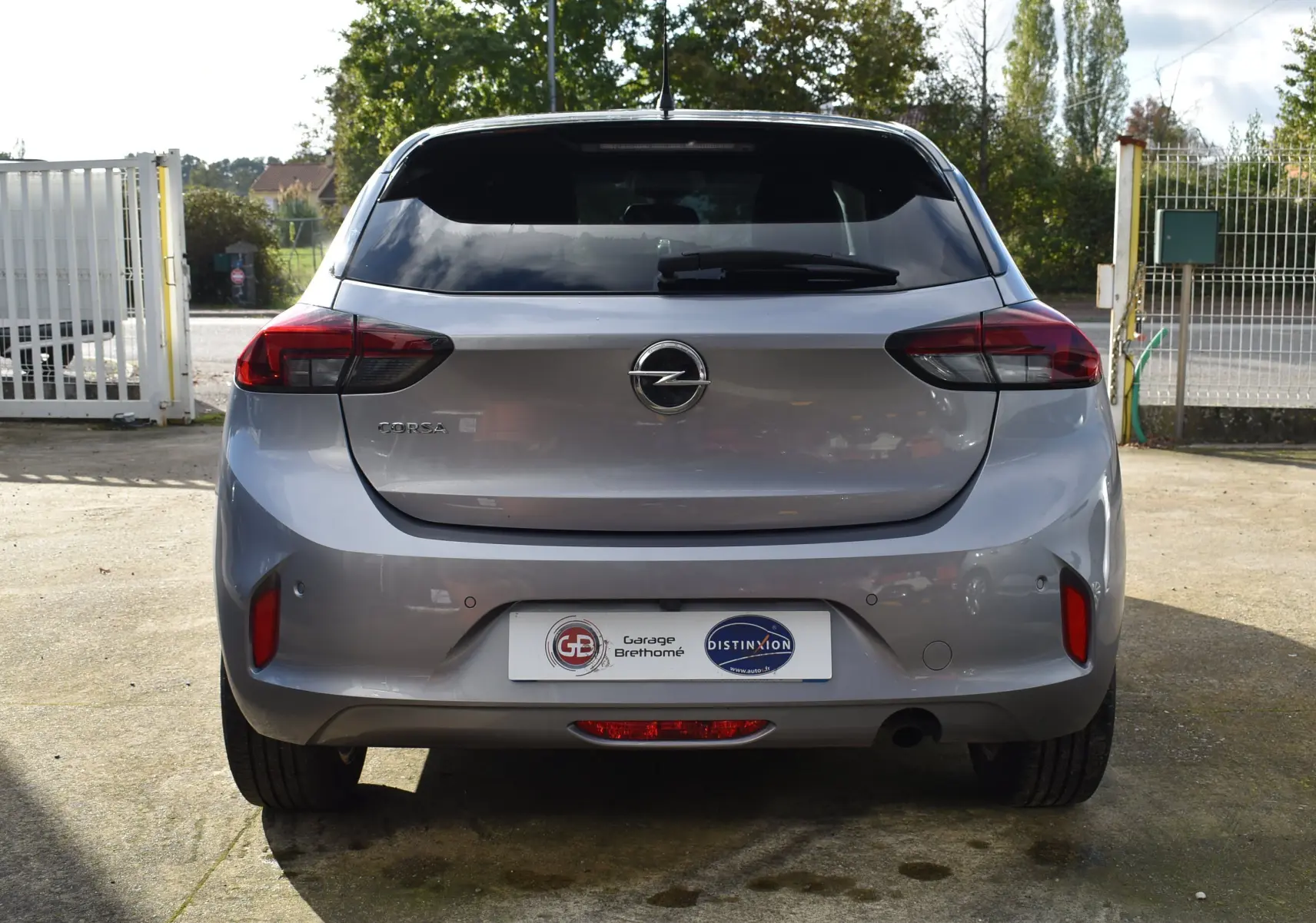 Vue arrière d'une Opel Corsa gris métallisé 2021 avec feux arrière LED et caméra de recul visible sur le pare-chocs.