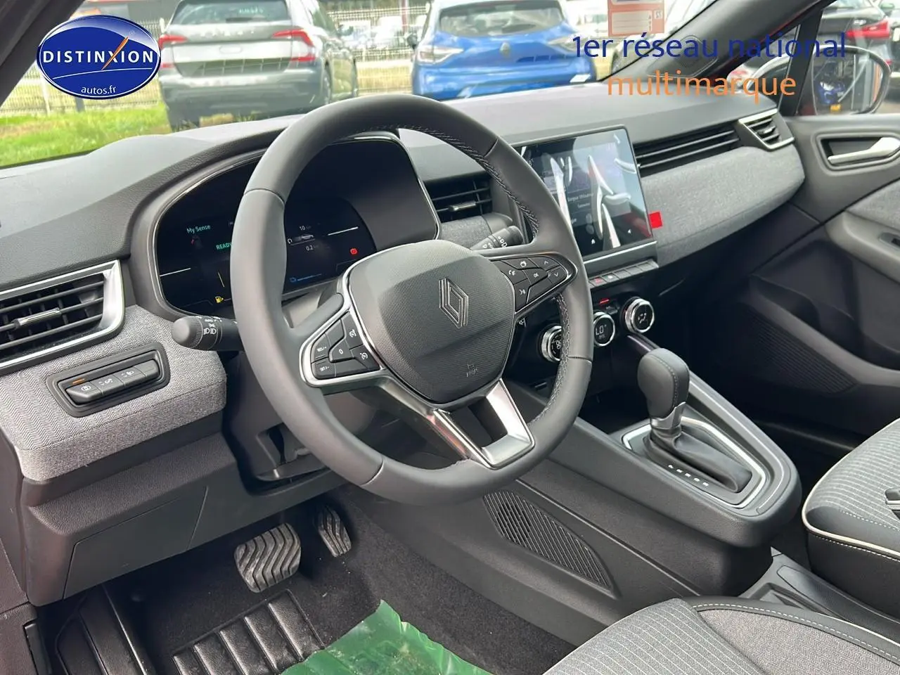 Intérieur Renault Clio V 1.6 e-tech 145 techno 2025, vue côté conducteur sur volant multifonction et console centrale.