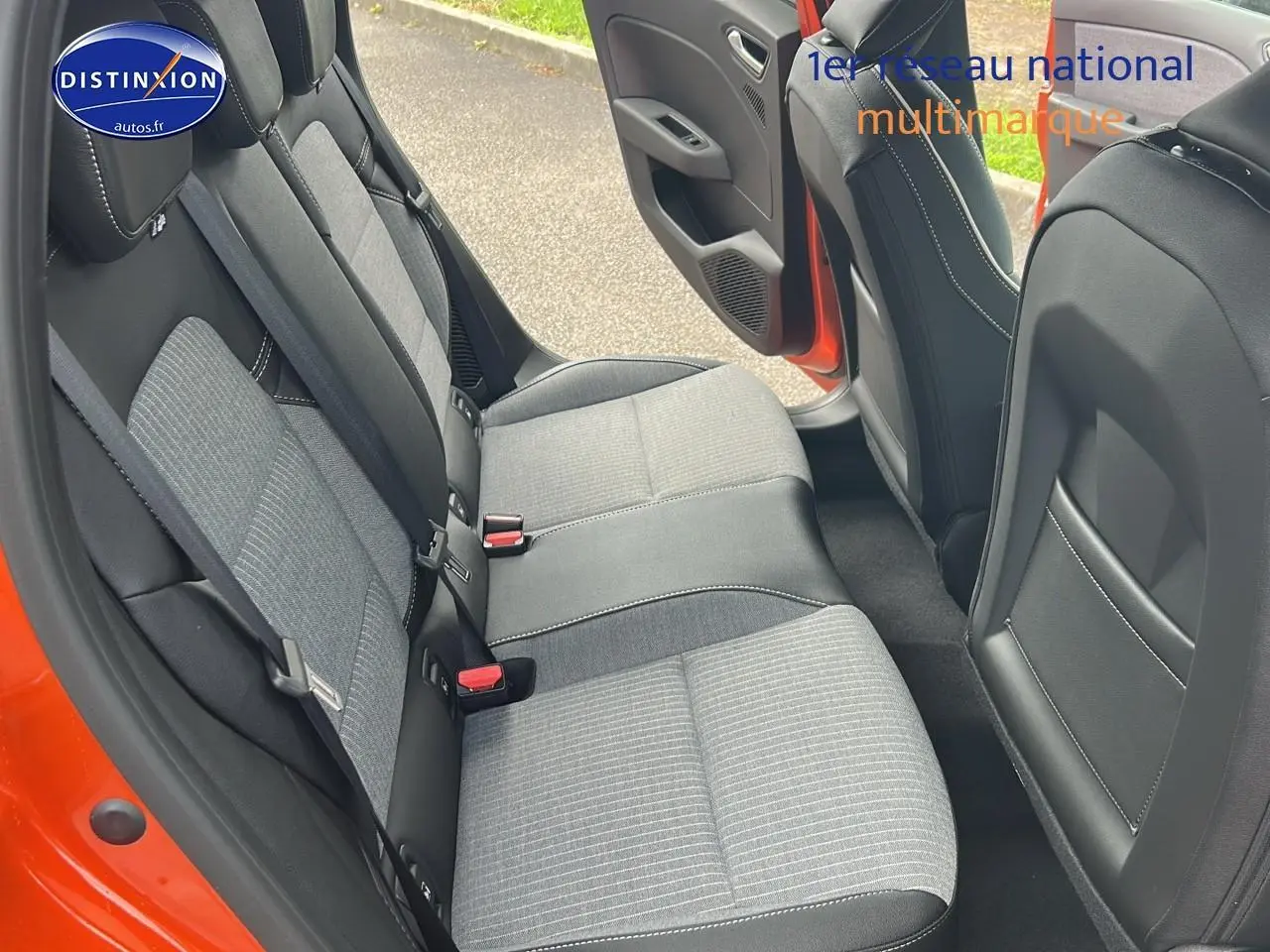 Vue intérieure sur la banquette arrière grise et noire de la Renault Clio V orange Valencia avec porte arrière ouverte.