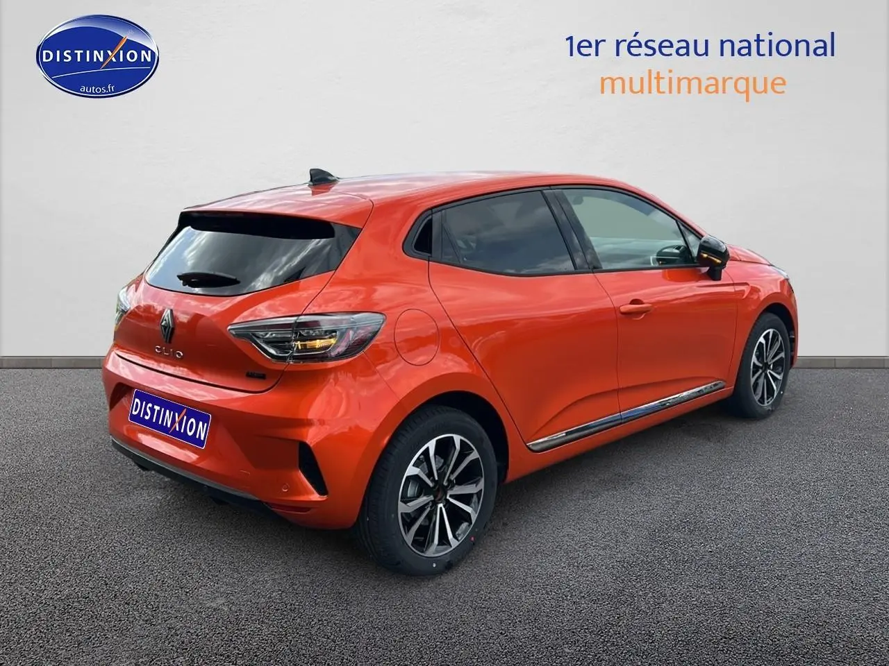 Renault Clio V orange Valencia vue 3/4 arrière droit avec jantes alu et vitres surteintées.