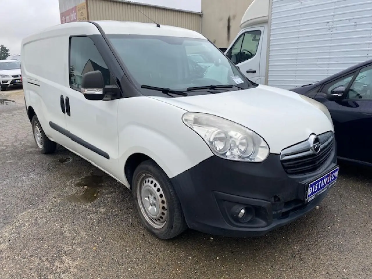 Vue 3/4 avant gauche d'un utilitaire Opel Combo blanc avec pare-chocs noir et porte latérale coulissante.