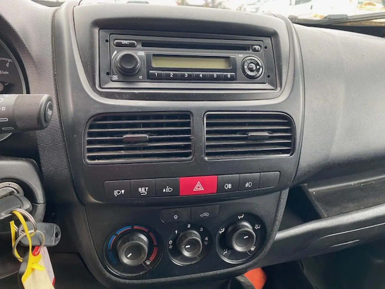 Tableau de bord intérieur de l'Opel Combo blanc 2016, vue frontale centrée sur la console avec autoradio et commandes climatiques.
